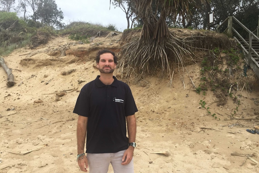 Phd student James Tucker stands on the beach in Coffs Harbour.
