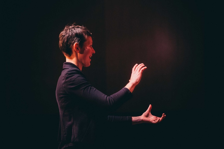 A profile view of a woman conducting.