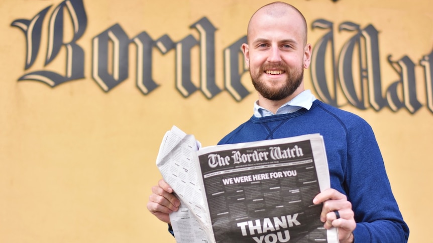 Man holds a newspaper
