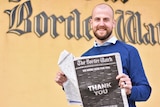 Man holds a newspaper