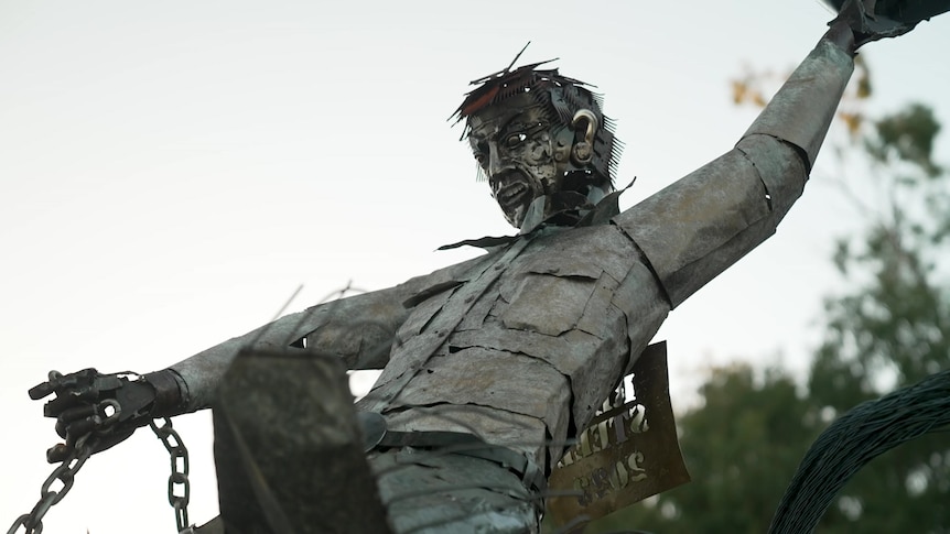 Image of a metal sculpture of a man riding a horse.