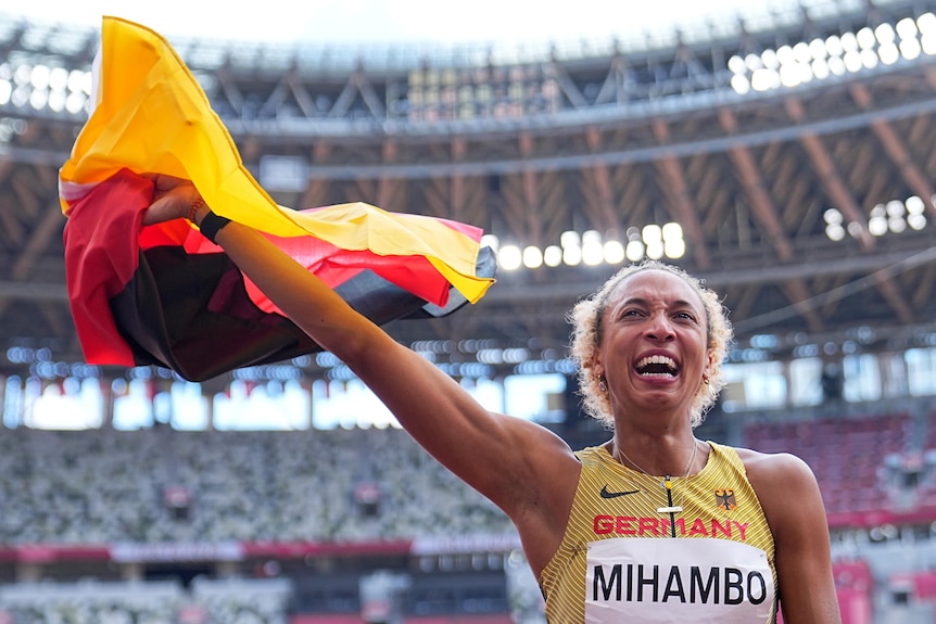 Women waving the Germany flag in the air after winning gold in the long jump at the Olympics