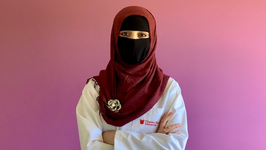 A woman with face veil wearing a lab coat