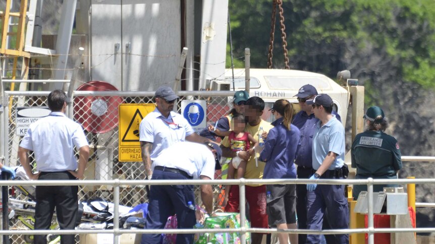 Customs officers and asylum seekers on the wharf