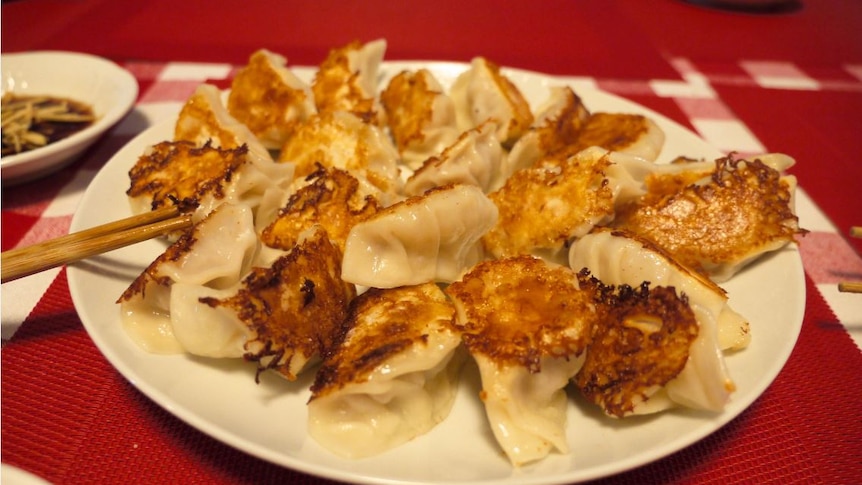 Fried dumplings on a plate on a red tablecloth during Lunar New Year festivities.