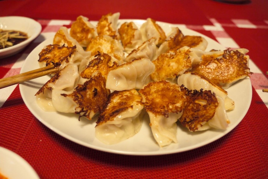 Fried dumplings on a plate on a red tablecloth during Lunar New Year festivities.