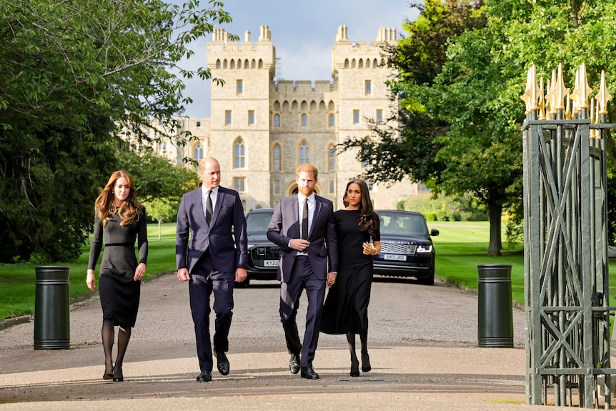 Princess Kate and Prince William dressed in black walk beside Harry and Meghan in front of Windsor Castle gates.