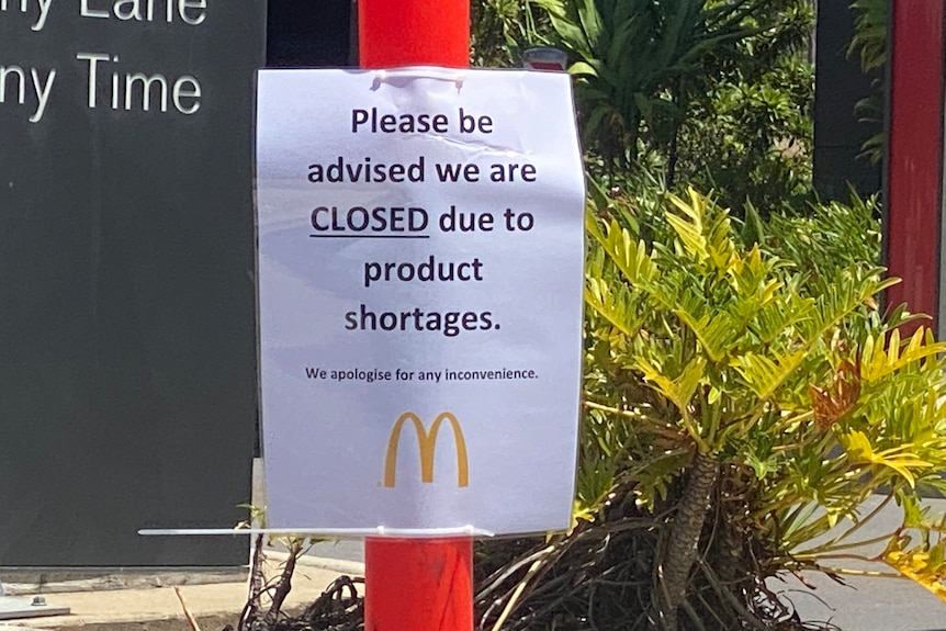 A sign that says please be advised we are closed due to product shortages, with the McDonald's golden arch underneath