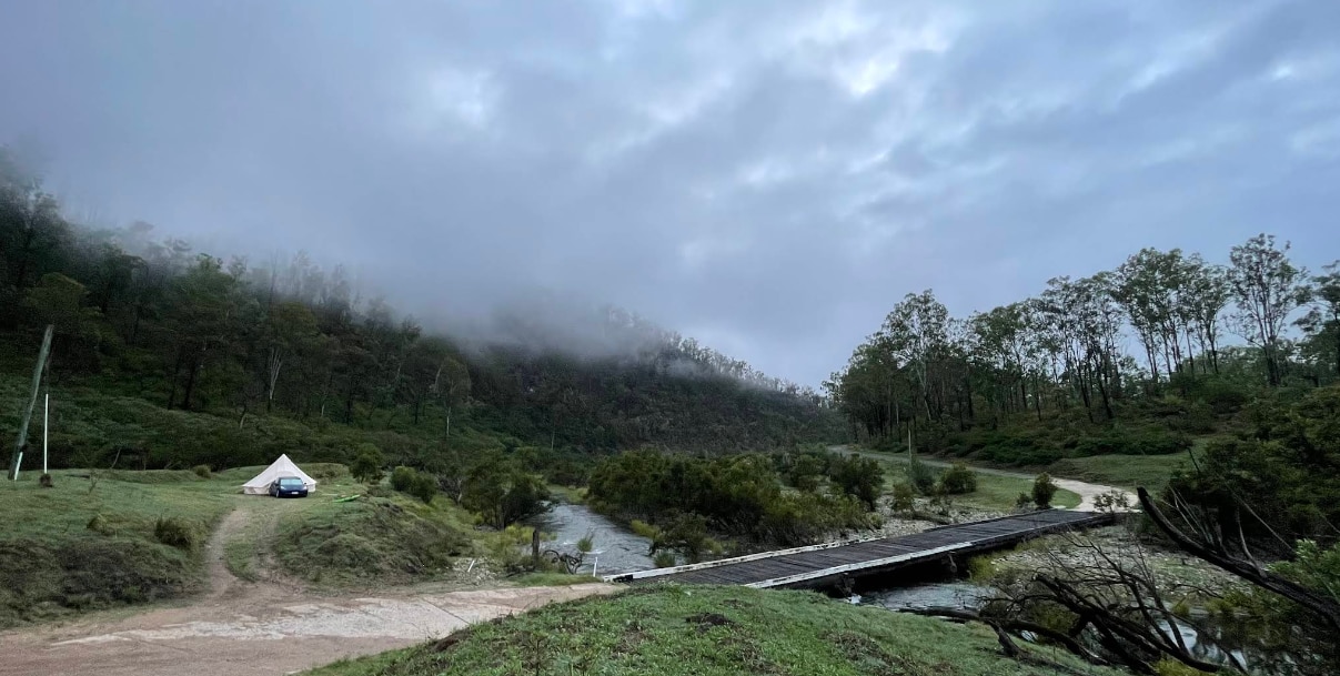 A causeway in a country area beneath a cloudy sky.