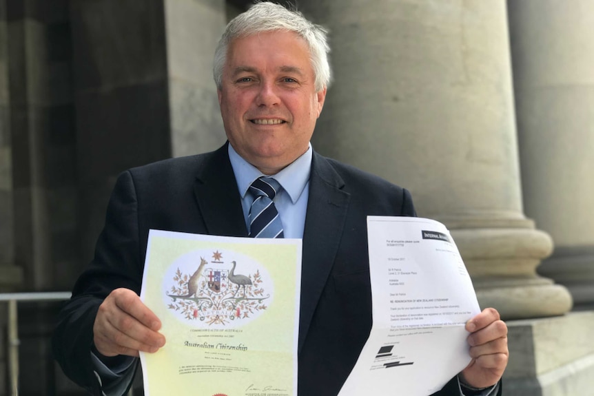 Rex Patrick holds up his Australian citizenship and paperwork showing he's renounced his New Zealand citizenship