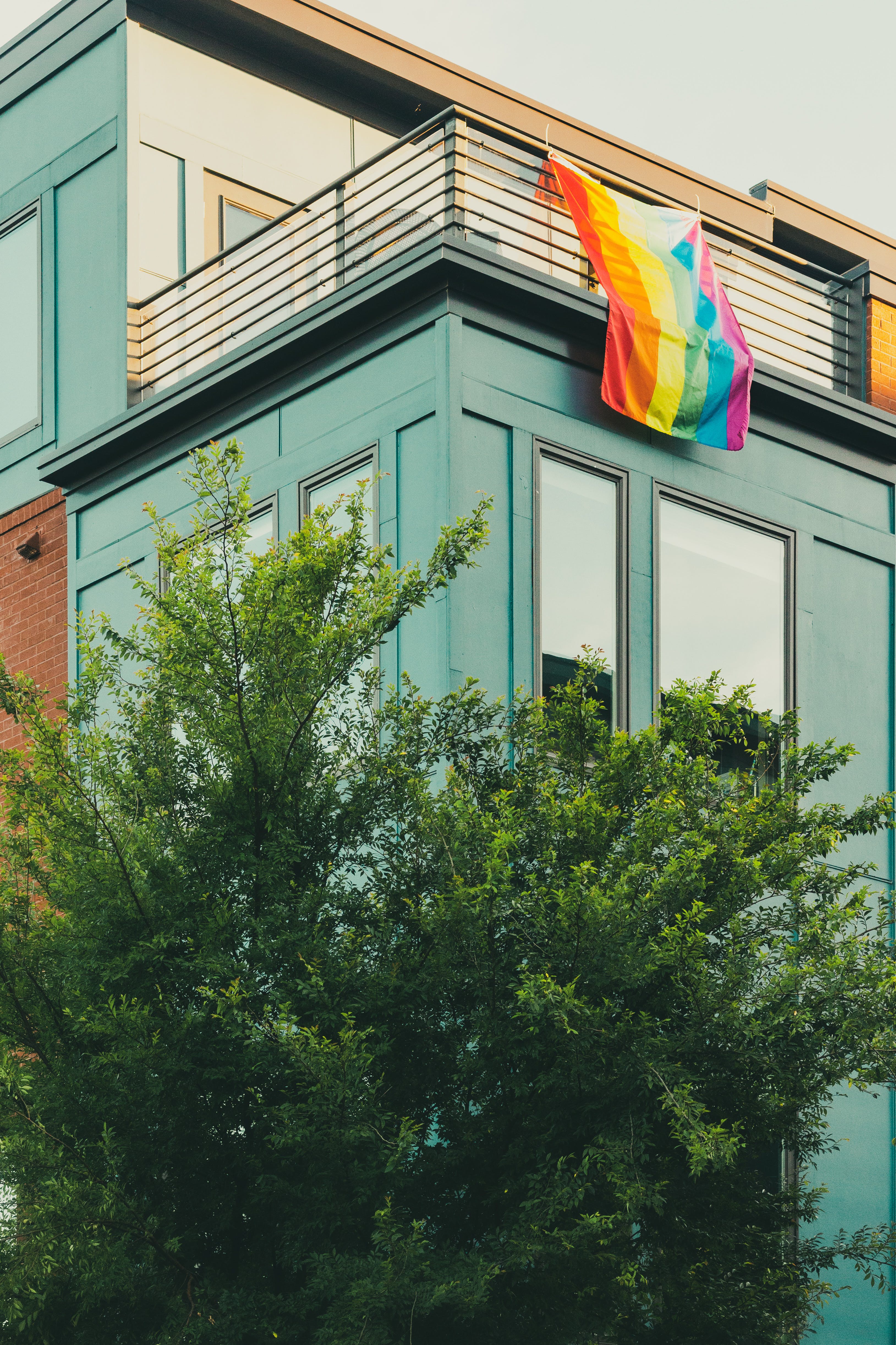 building with rainbow pride flag draped over balcony