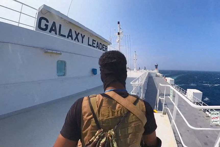 the back of a man with a mask on on  acargo ship