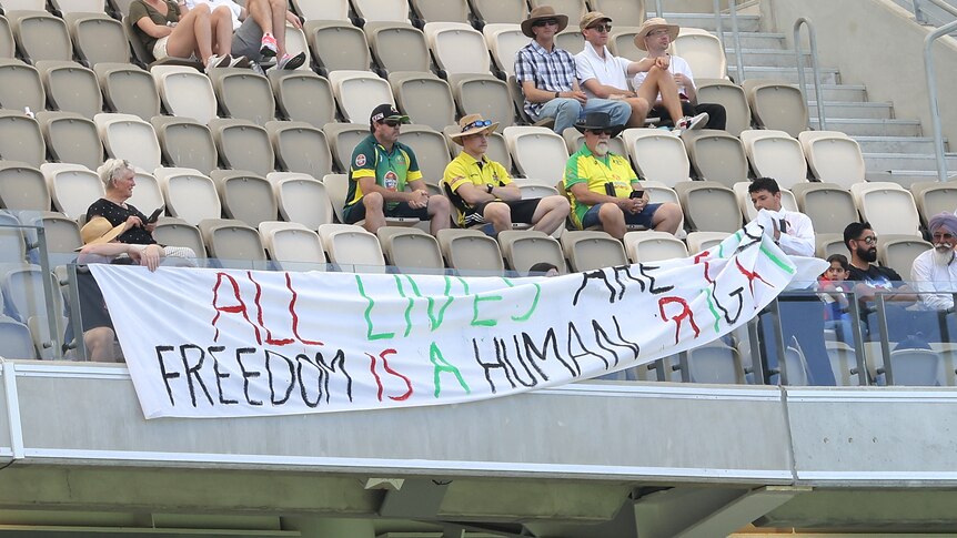 A banner is removed by security during the Australia vs Pakistan cricket Test in Perth.