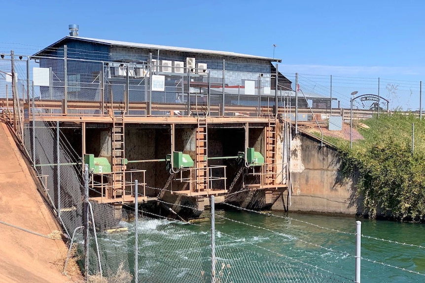 Irrigation gates and channel with building behind