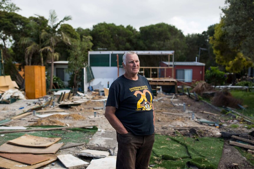 James Paul stands amid the wreckage left where a house used to be.