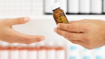 Pharmacist hands customer bottle of pills (Thinkstock: Stockbyte)