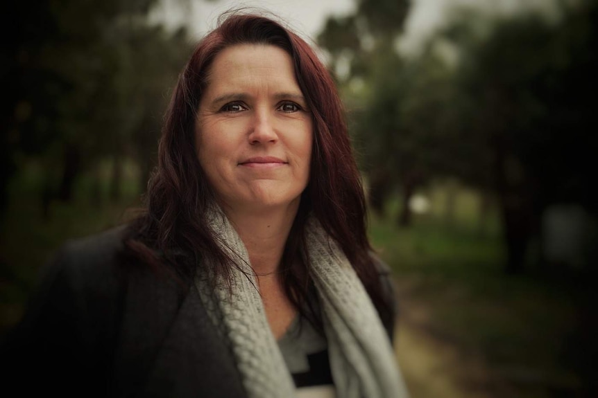 Portrait shot of a woman with dark red hair.