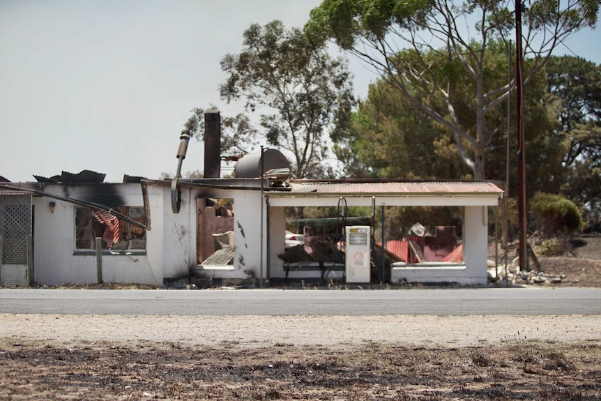 A service station appears scorched by fire.