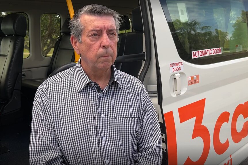 Man stands outside a 13cabs taxi
