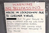A warning sign with neat and multi-coloured writing taped to a door