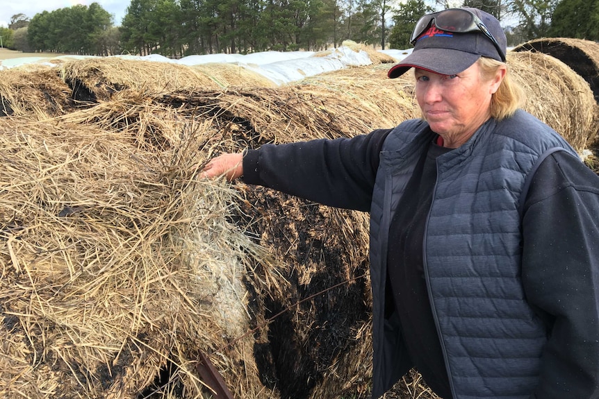 Ebor farmer with burnt hay bale