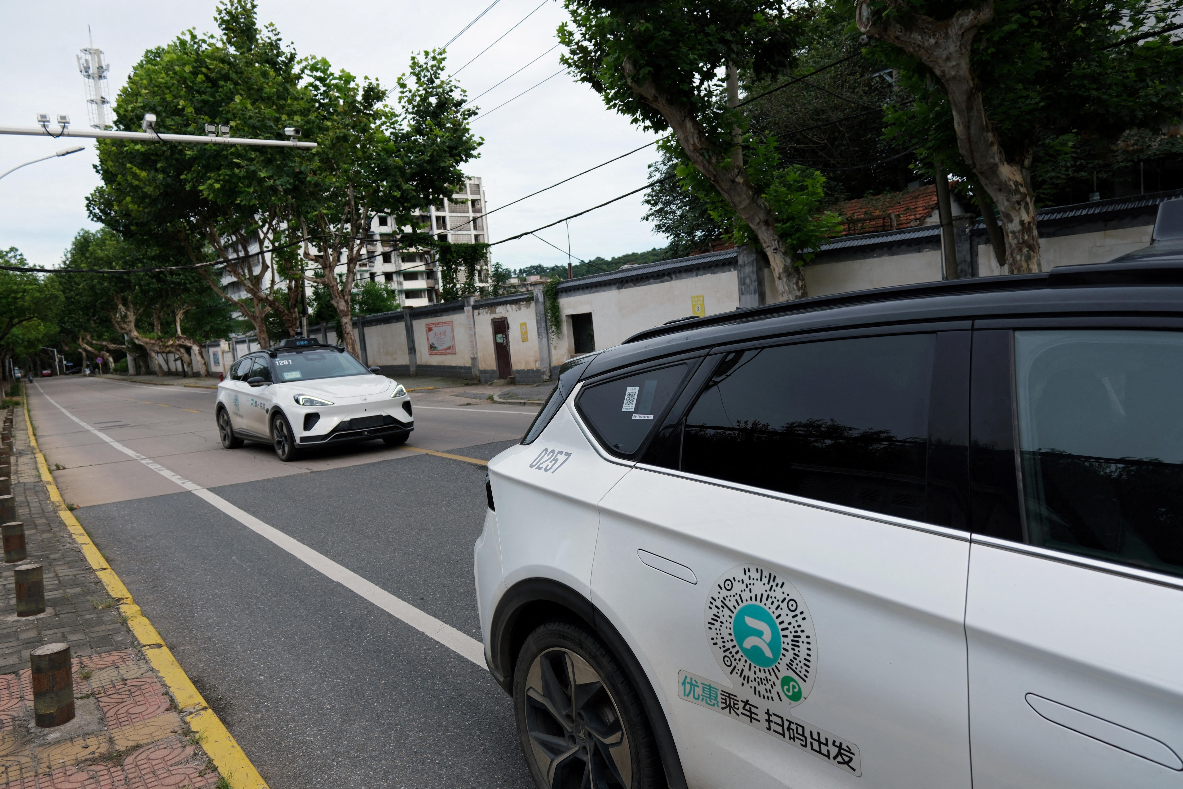 Two white cars on a road in China.