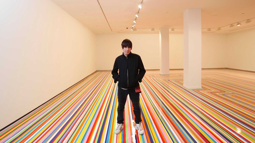 Jim Lambie stands on his Zobop floor during the 19th Biennale of Sydney at the MCA in Sydney.