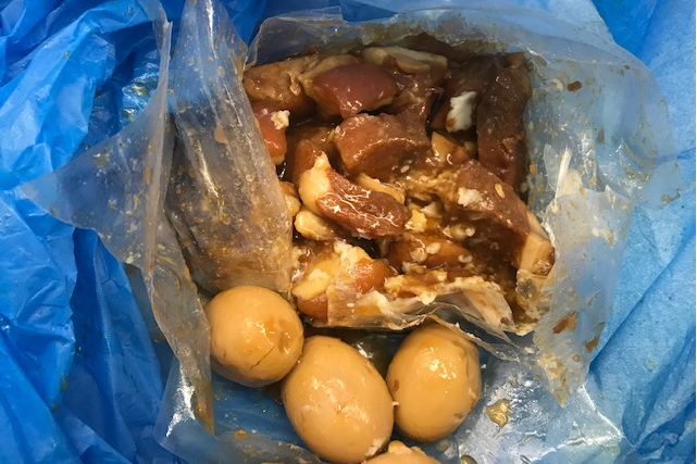 Picture of imported pork in a plastic bag next to eggs.