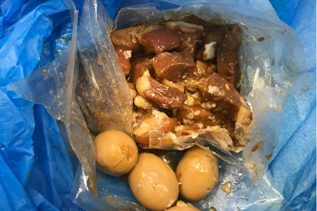 Picture of imported pork in a plastic bag next to eggs