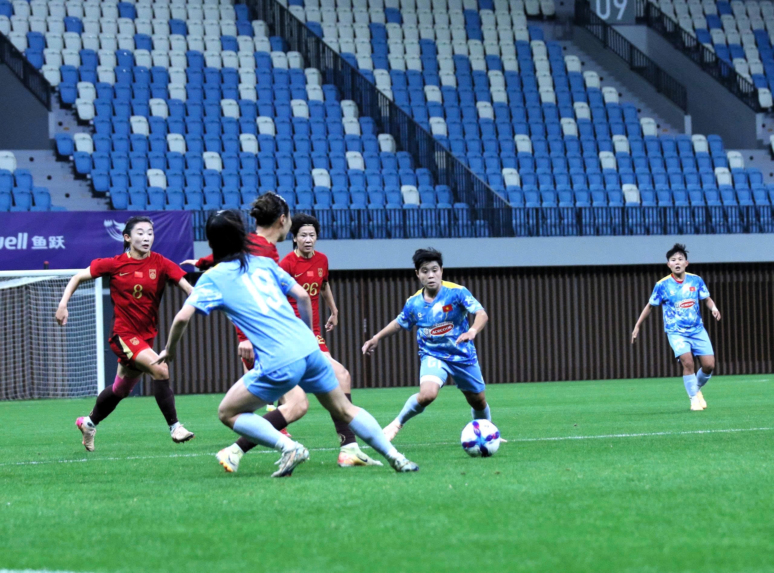 Uma jogadora de futebol vietnamita se prepara para chutar a bola durante um jogo.