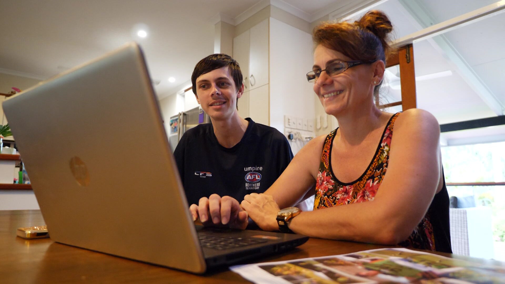 Jonty Beard and his mum Wendy sit at a table with a computer open.