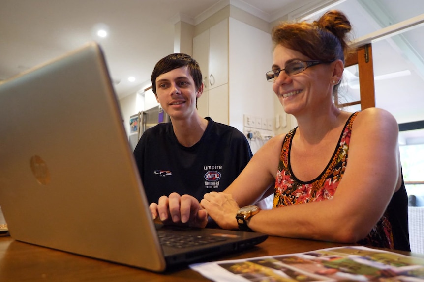 Jonty Beard and his mum Wendy sit at a table with a computer open.