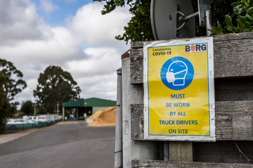 A sign with a BORG logo saying truck drivers must wear masks at all times