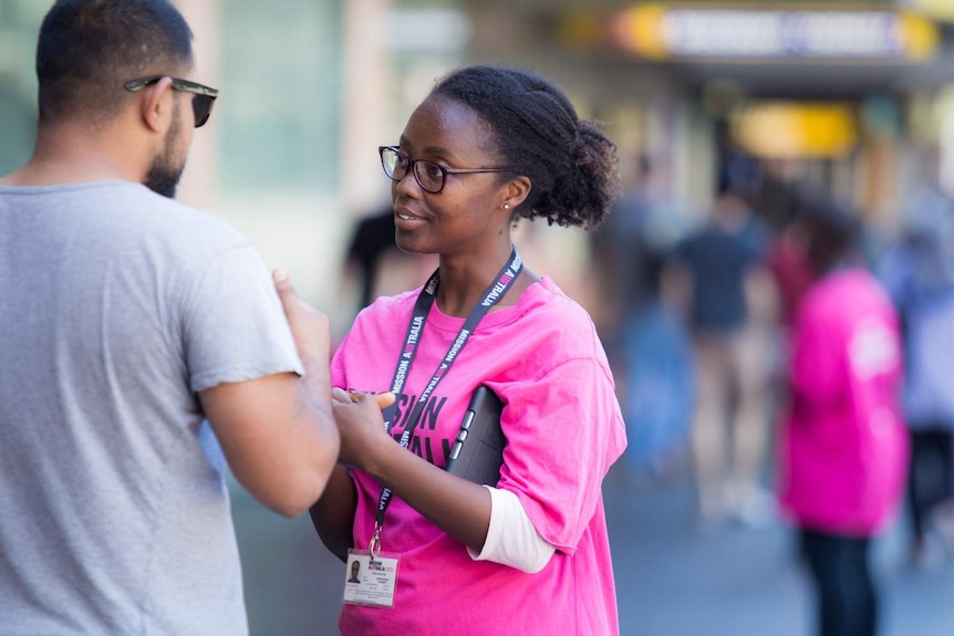 woman in pink shirt talking to man in shirt