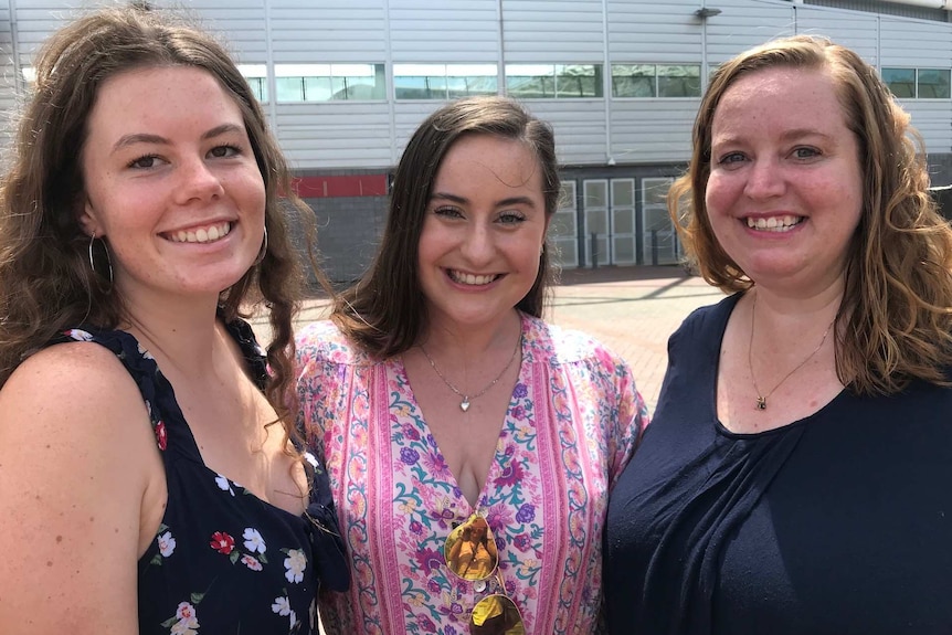 Three woman smile for the camera