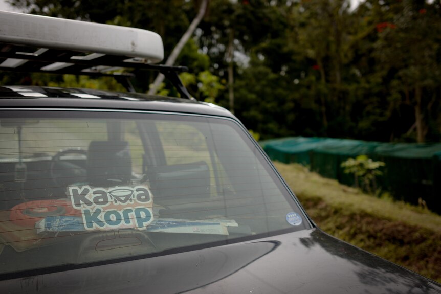 A sticker on a car reads 'Kava Korp' with the nursery in the background. 