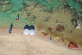 Drone shot of a rock pool in Kalbarri with beach umbrellas on the shore
