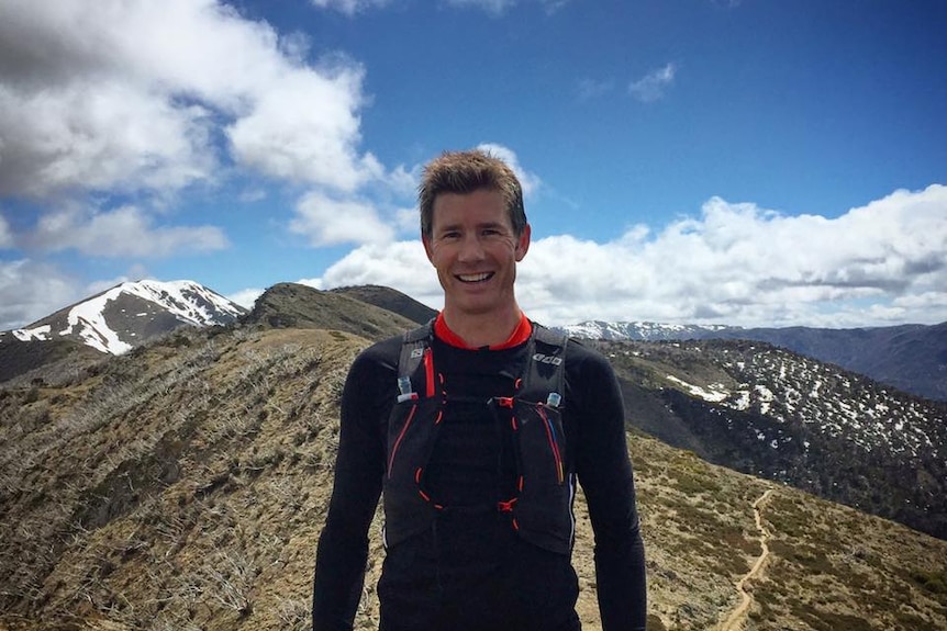 Man stands on top of mountain