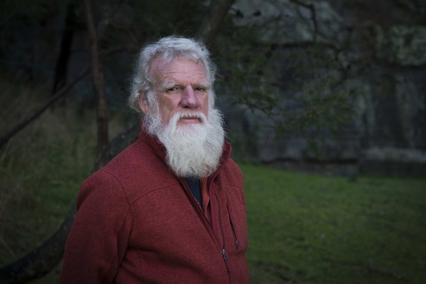 The writer Bruce Pascoe standing in front of a garden