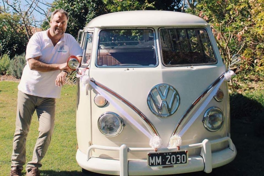 Mitchell Montgomery standing next to a 15 window Kombi van.