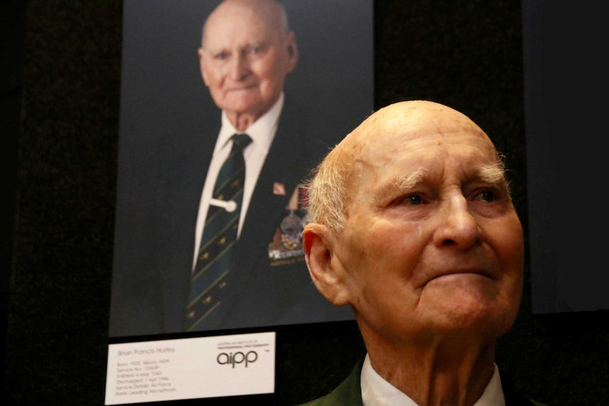 Brian Hurley in front of his portrait.