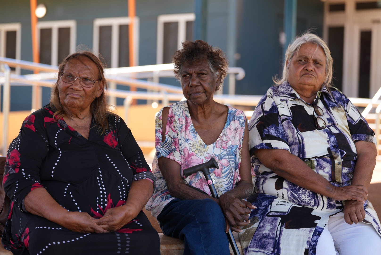 A trio of Aboriginal elder women with serious expressions.