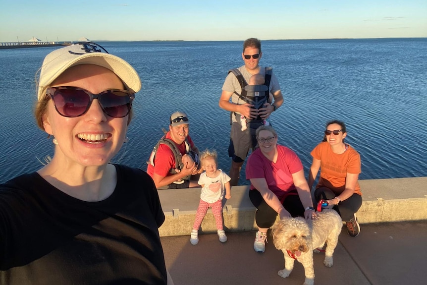 Brittany takes a selfie with family and a lake behind her.