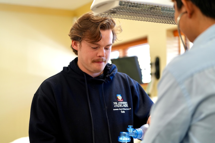 A young man with brown hair and a blue hoodie at the Broken Hill University Department of Rural Health