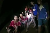 Screenshot taken from video shows blurred faces of boys looking at rescuers.