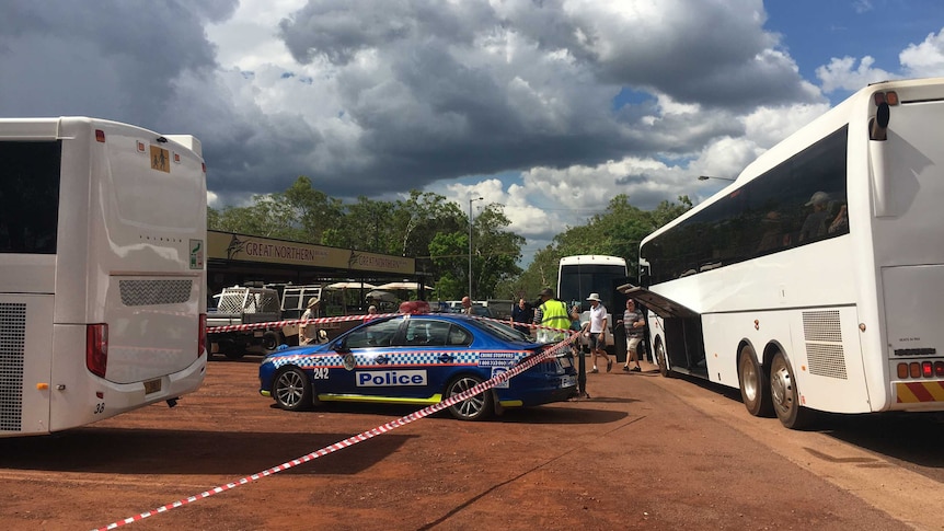 Tourist buses and a police car in the carpark of a pub.