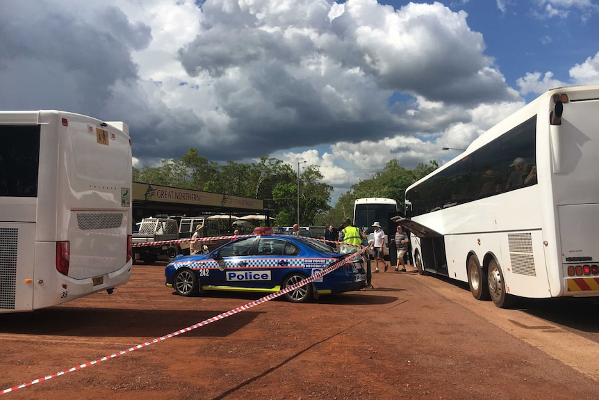 Tourist buses and a police car in the carpark of a pub.