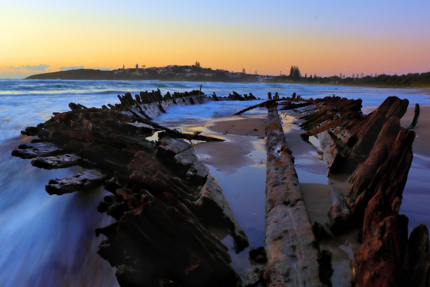 A shipwreck with waves washing around it.