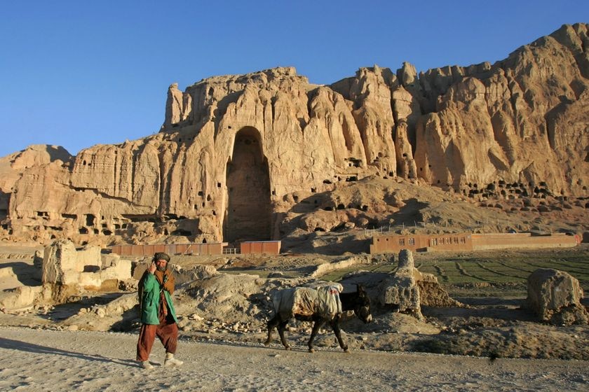 2001 年 3 月，一名阿富汗男子走过被塔利班摧毁的巨大佛像的残骸。