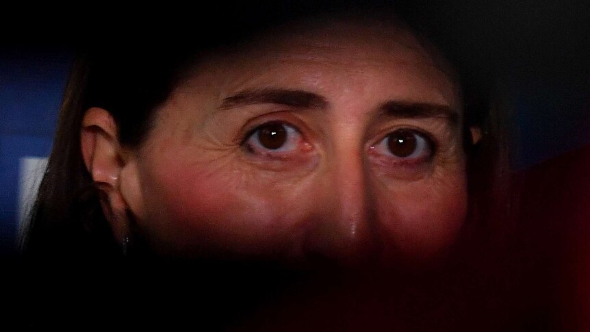A close up of a woman's illuminated eyes, while the rest of her face is in the dark